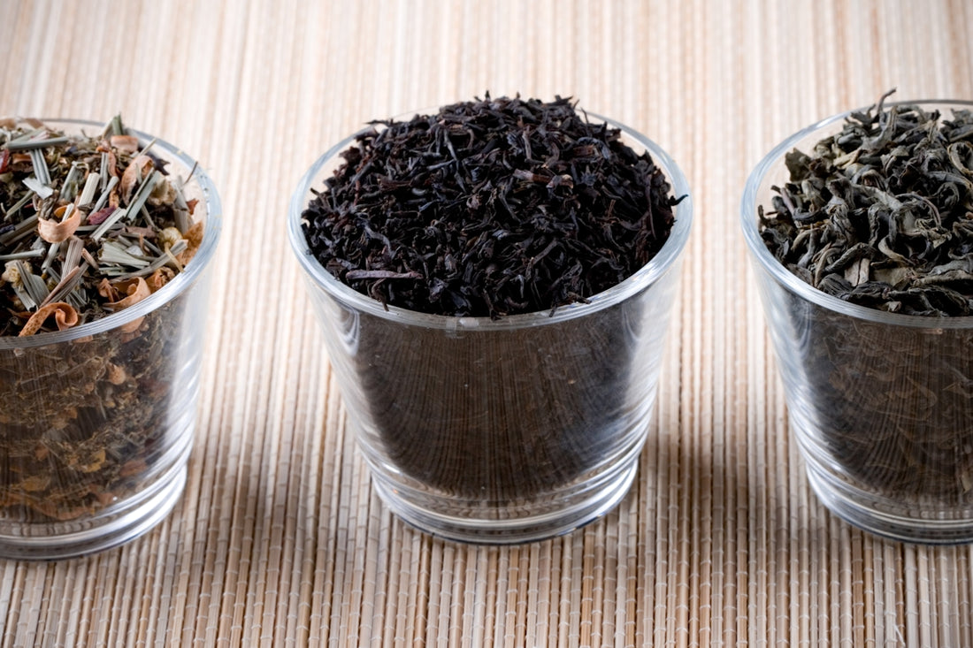 Three glass cups filled with different types of tea