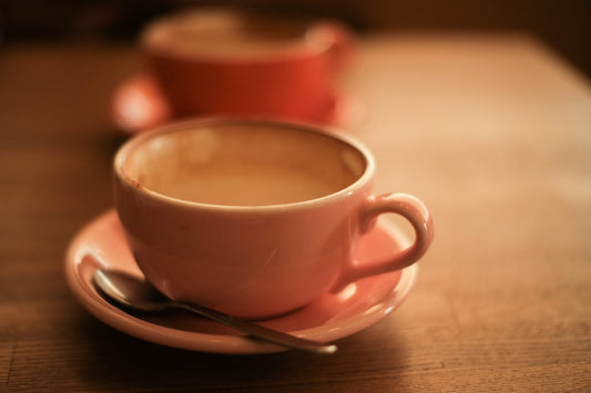 white ceramic teacup with saucer on brown wooden table