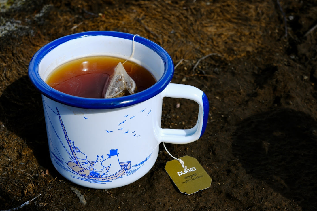 A cup of tea sitting on top of a dirt ground