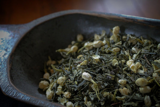 A bowl filled with green tea on top of a wooden table