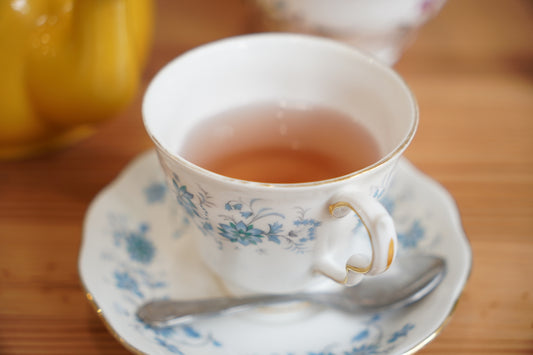 Tea is served in a floral teacup and saucer.